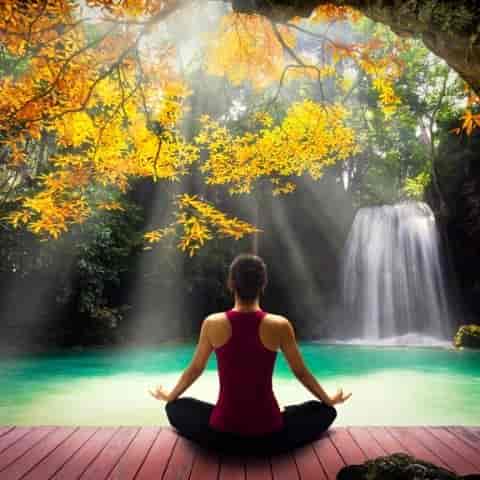 A woman meditates by water