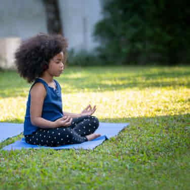 a child meditates outside