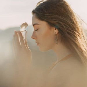 a woman focuses with a healing crystal