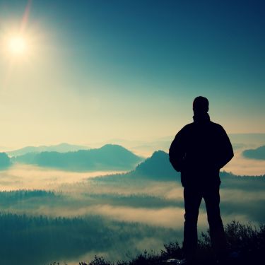 a man on a mountain top praying for a miracle