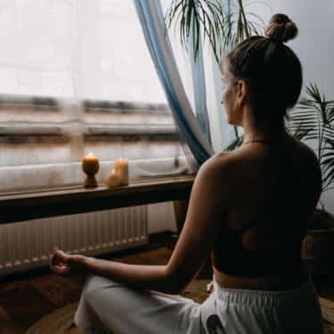 a person meditates on a meditation cushion