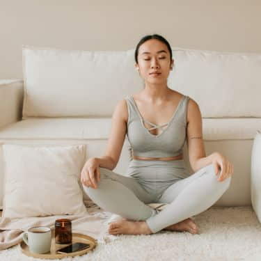 a woman meditates at home